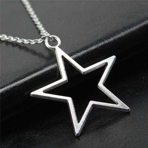 Styled view of open star outline pendant necklace in polished silver tone