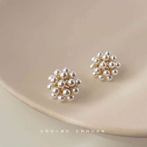 White pearl cluster flower studs on beige ceramic plate
