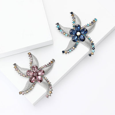 Purple and blue crystal starfish flower brooches on white blocks