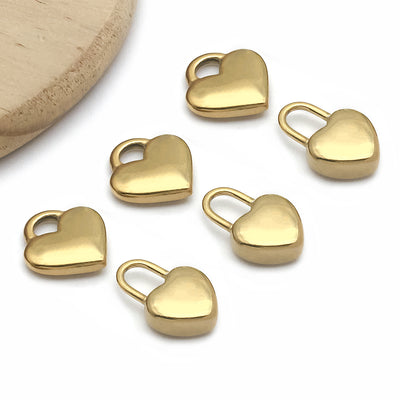 Gold-tone heart charms arranged on a light background