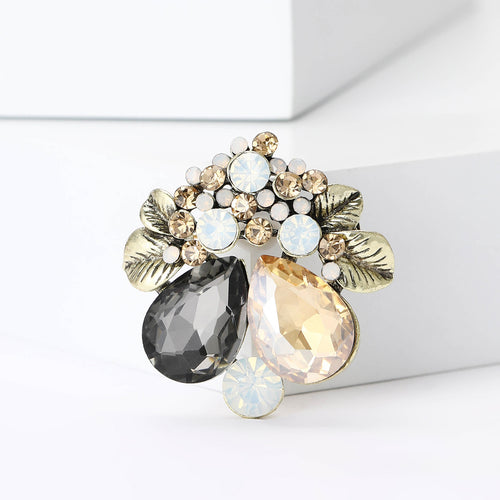 Angled display of the floral teardrop crystal brooch on a white surface