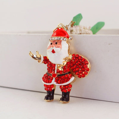 Red rhinestone Santa figure holding a round sack beside a white planter.