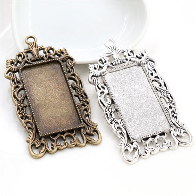 Front overview of ornate rectangular pendant trays in silver and bronze tones arranged on a light background