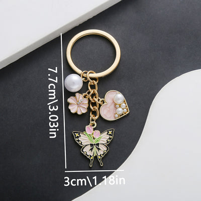 Front product photo of pink blue and purple heart pearl flower butterfly keychain showing the pictured design arrangemen