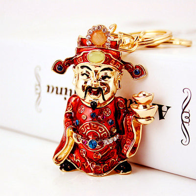 Detailed view of the gold-tone face, red robe, blue accents, and ingot stack.