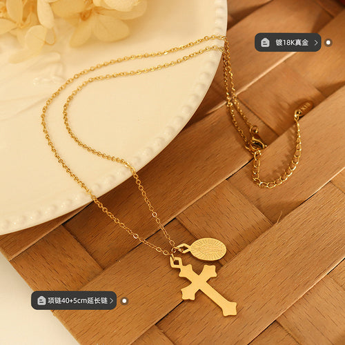 Gold cross medal necklace flat on wood with plating and length labels