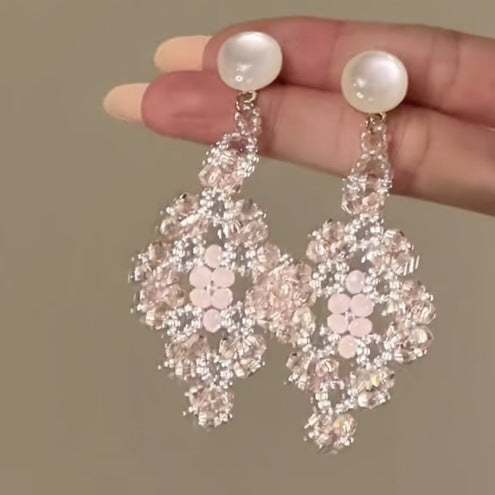 A styled close view of the crystal chandelier earrings.