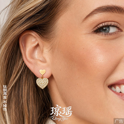 On-ear view of crystal heart hoop earrings in main image 1.