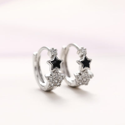 Silver black star clear pavé star huggie earrings pair front