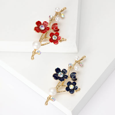 Front view of pearl and enamel blossom branch brooch in blue and red