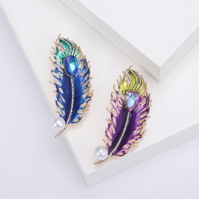 Front view of the colorful crystal feather brooch with pearl accent decorative clothing pin on a white background