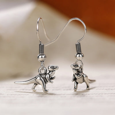 Tiny dinosaur dangle earrings in front product view