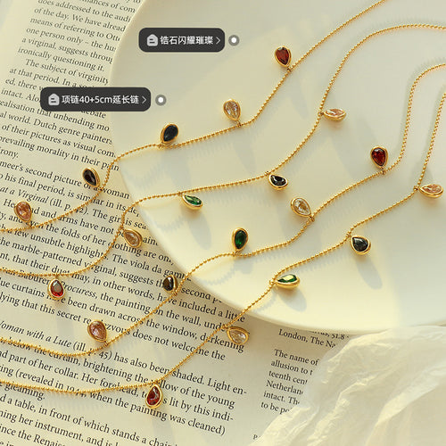 Gold teardrop CZ necklaces flat lay with length and stone labels