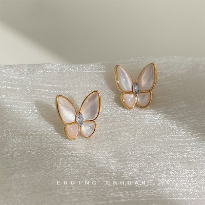 Gold-tone white-pearlescent butterfly clear-stone studs in the first product display.