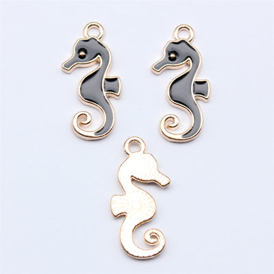 Black-and-white seahorse charm shown on a hand for scale