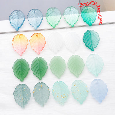 Large glass leaf charms in twelve finishes arranged as a full product overview