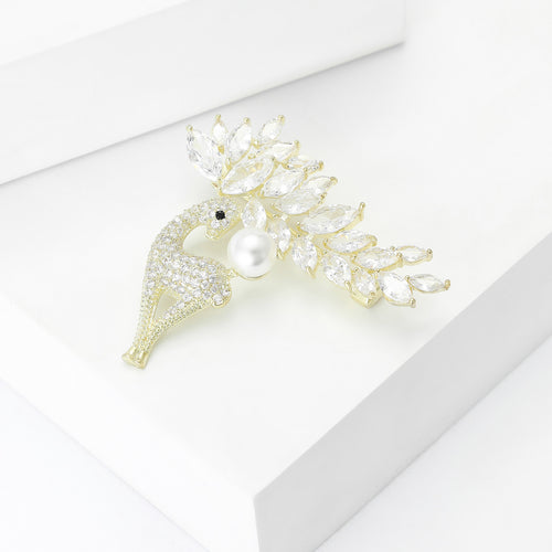 Gold deer brooch angled on white blocks showing crystal paving