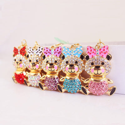 Five gold-tone rhinestone bear charms with red, white, purple, blue, and pink bows.