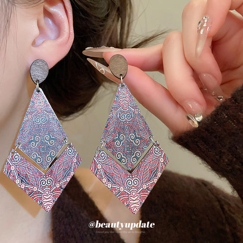 Close view of the colors and surface details on pink patterned diamond wood drop earrings