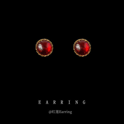 Gold wine red round cabochon stud earrings on black background