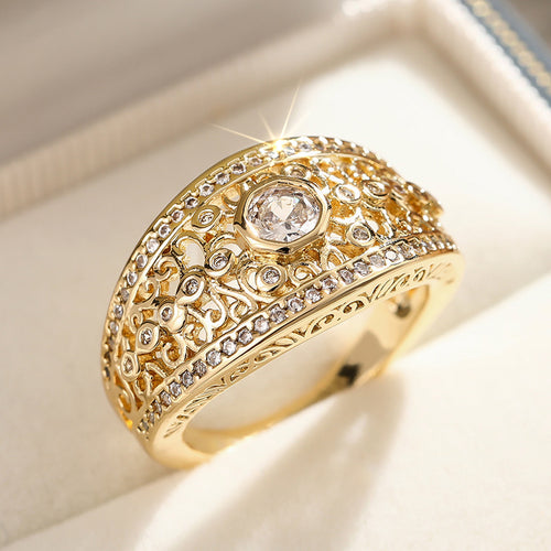 Gold openwork scroll ring with center stone in white jewelry box