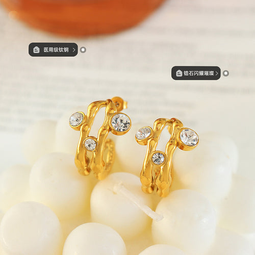 Pair of gold twisted open hoops with zircon on white beads