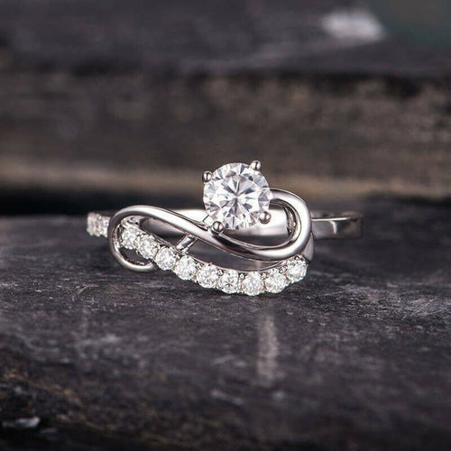 Product view showing silver-tone round clear solitaire swirl pave ring