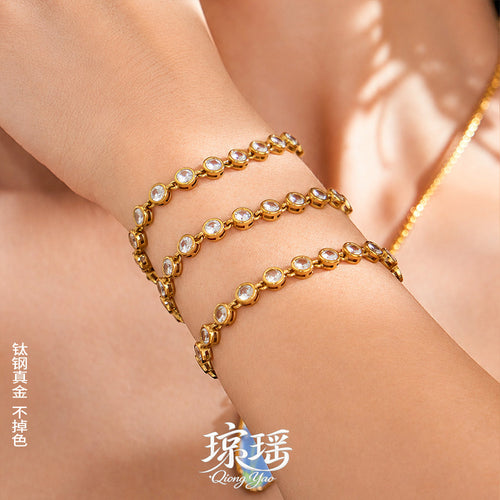 On-wrist view of gold tone bezel crystal tennis bracelets in main image 1.