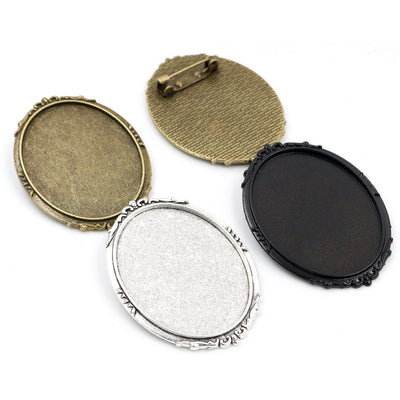Overview of oval recessed trays fitted with both a top bail and a pin back in four metal finishes