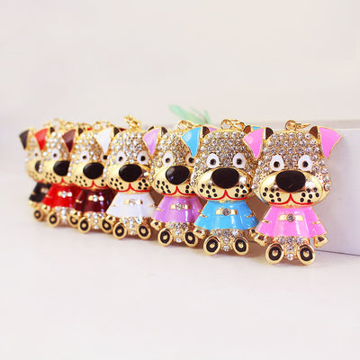 Seven gold-tone dog charms in assorted enamel colors arranged in a row.