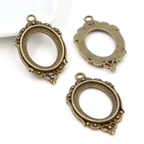 ornate oval cabochon pendant frames shown in a close detail view