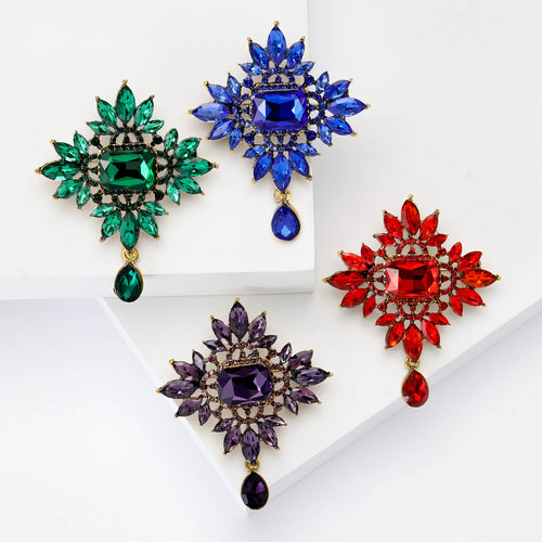 Angled display of the radiant crystal dangle brooch on a white surface