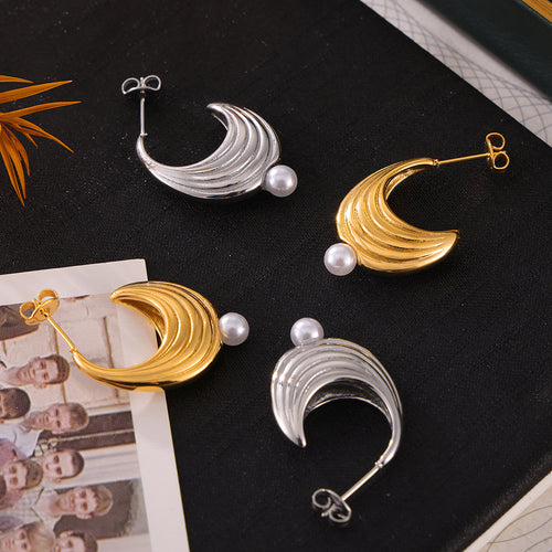 Gold and steel ribbed crescent studs with white pearls on black