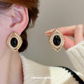 Gold Tone Oval Textured Stud Earrings with Black Centers view 1