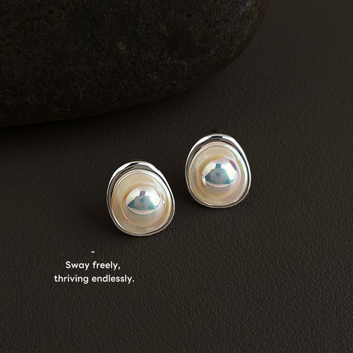 Silver-tone irregular oval white-pearlescent studs in the first product display.