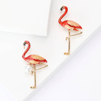 Front view of the red flamingo brooch in two poses with polished metal detail on a white background