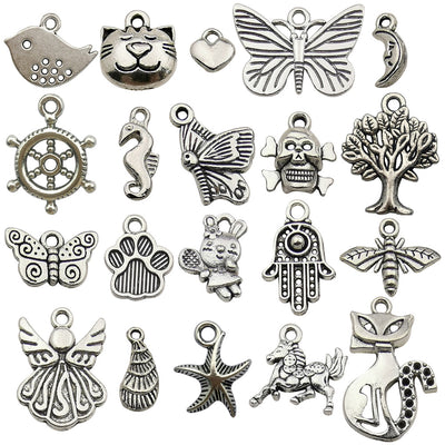 Antique silver butterfly and seahorse charms arranged on a light background