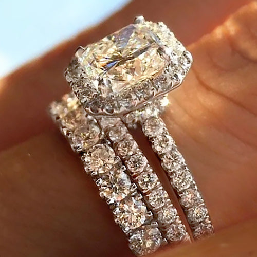 Front angle of emerald halo stack with two pave bands on finger