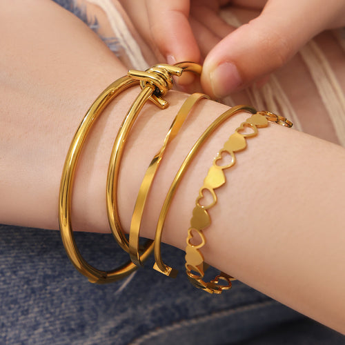 On-wrist view of heart link and geometric bangle collection in main image 2.