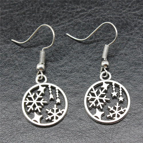 Close view of snowflake and star round drop earrings in silver tone