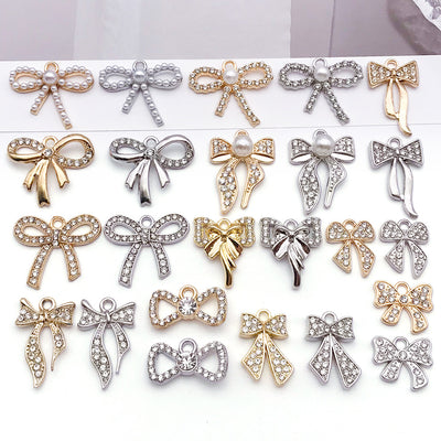 Metallic bow and butterfly charms arranged on a light background