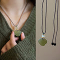 Green Cloud Pendant Necklace on Layered Brown Cords view 1