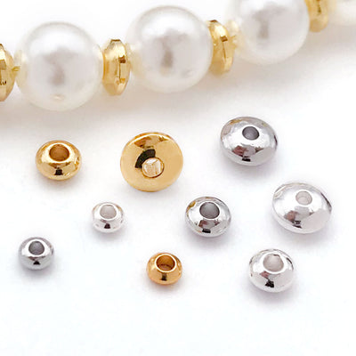 Gold-tone spacer bead beads arranged on a light background