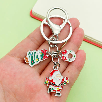 Image 1 showing a hand holding a keychain with santa claus.