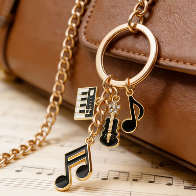 Front product photo of piano violin and music note charm keychain showing the pictured design arrangement