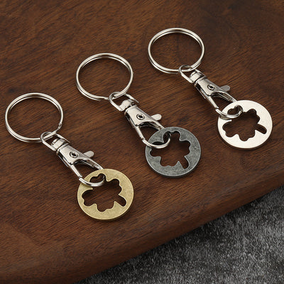 Three clover cutout token keychains on wood