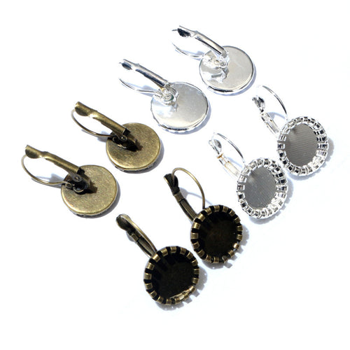 Overview of scalloped round leverback bezel settings in antique bronze and silver tones on a light background