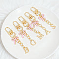 Gold Tone Initial Letter Keychain With Pink Enamel Bow Charm view 2