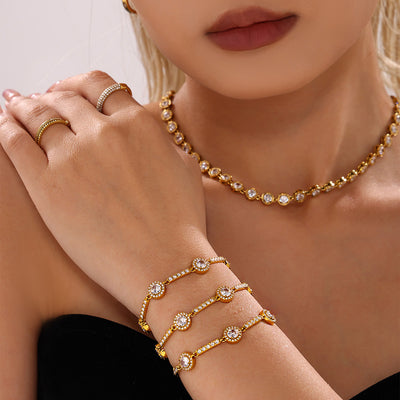 Three gold halo zircon station bracelets stacked on model wrist