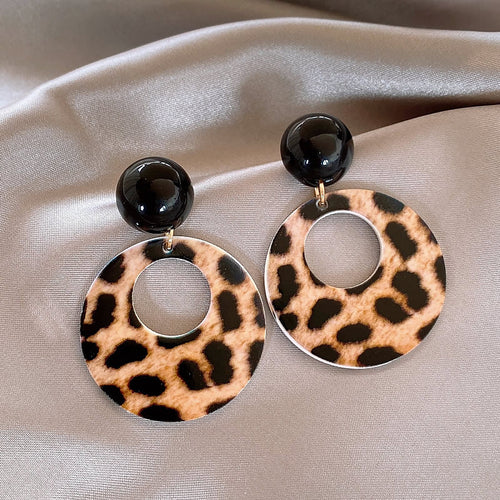 Styled view of leopard print open circle drop stud statement earrings